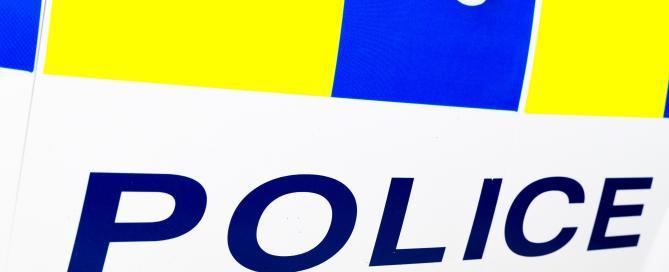 A close-up of the side of a car with POLICE printed onto it.