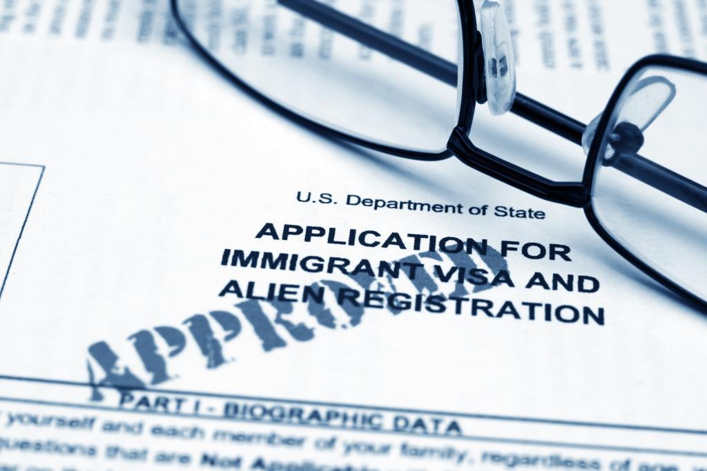 a us department of state visa application form with a pair of glasses on top